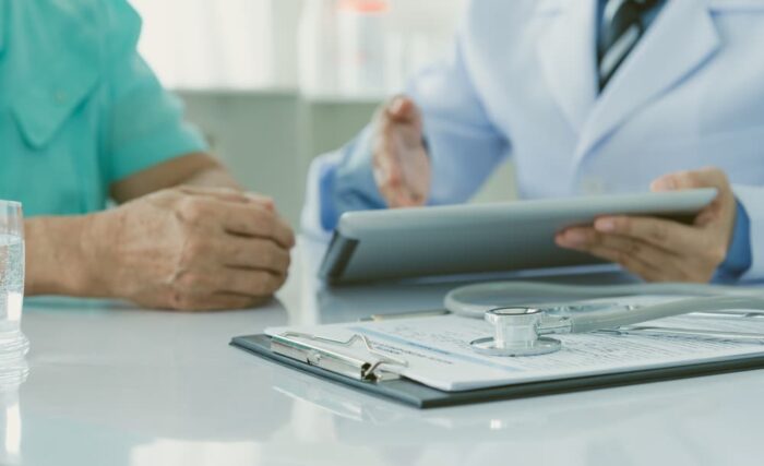 Healthcare provider helps patient fill out form.