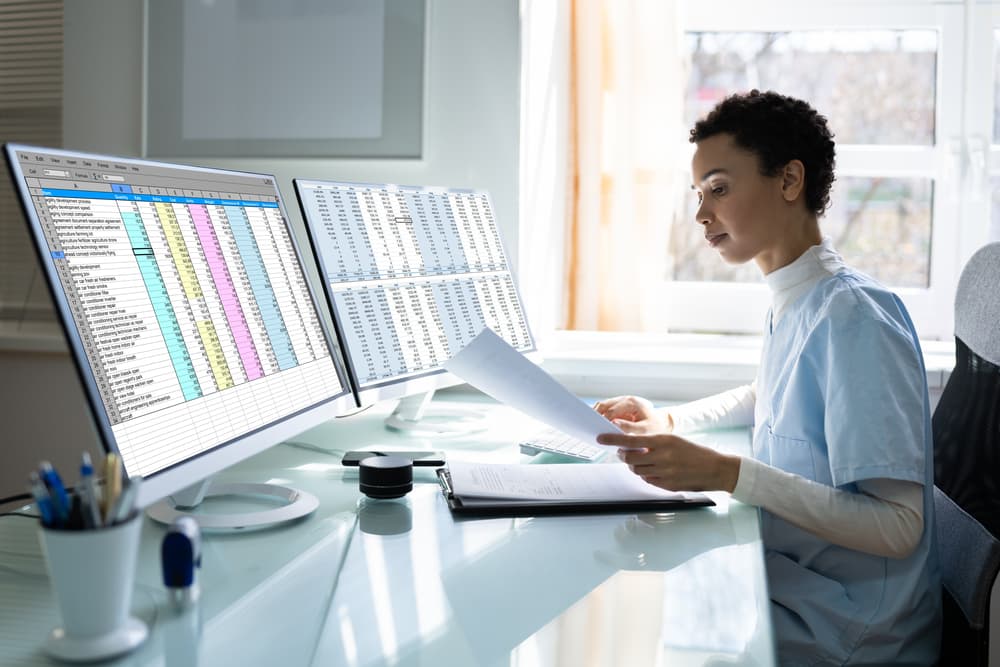 Healthcare provider analyzes spreadsheet on her computer.